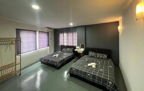 a bedroom with two beds and a table and a desk at GD HOMESTAY in Kulai
