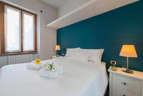 Un dormitorio con una gran cama blanca con flores. en Heart Centre Milan Navigli 3 Levels Apartment en Milán
