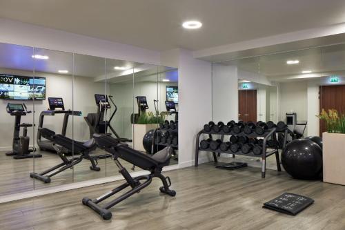 a gym with treadmills and exercise equipment in a room at Maison Albar Hotels Le Pont-Neuf in Paris