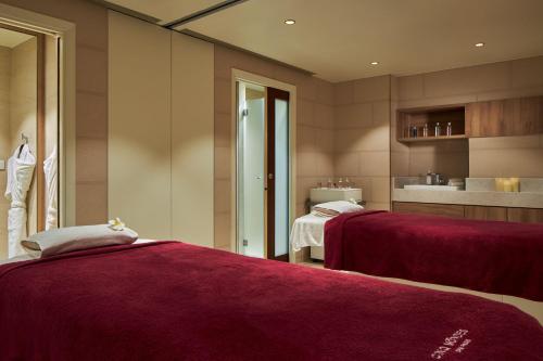 two beds in a room with red sheets at Maison Albar - Le Pont-Neuf in Paris