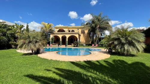 a house with a swimming pool in the yard at Riad Noumidya in Fez