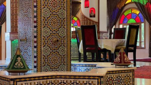 a dining room with a table and chairs and colorful walls at Riad Noumidya in Fès