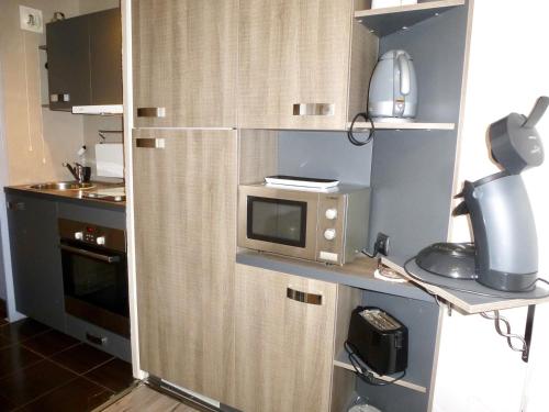 a small kitchen with a microwave on a counter at Boost Your Immo Barèges Oncet PM3 in Barèges