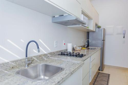 a kitchen with a sink and a refrigerator at Smart Studio Cataratas Luxo in Foz do Iguaçu