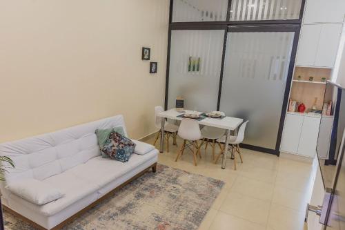 a living room with a white couch and a table at Smart Studio Cataratas Luxo in Foz do Iguaçu