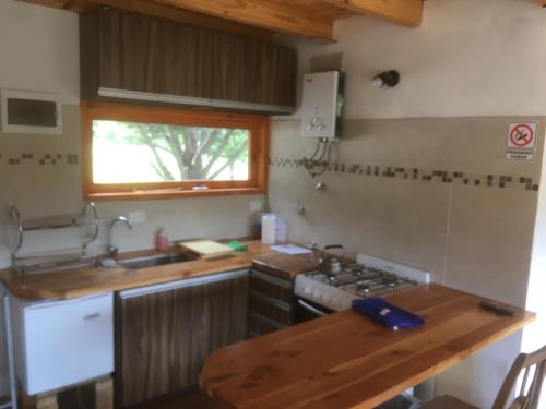 a kitchen with a sink and a stove top oven at Casa de la ventana in Villa Meliquina