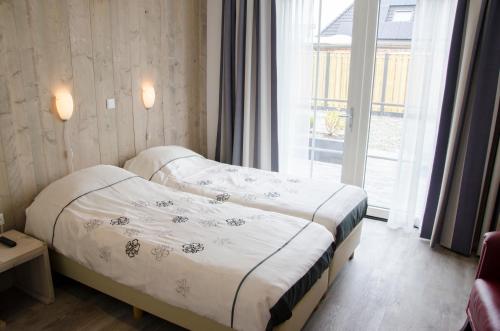 a hotel room with two beds and a window at Wil's Bed & Breakfast in Zoutelande