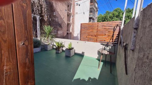 uma varanda com um banco e vasos de plantas em Terracita /mini casa centrica em Mendoza