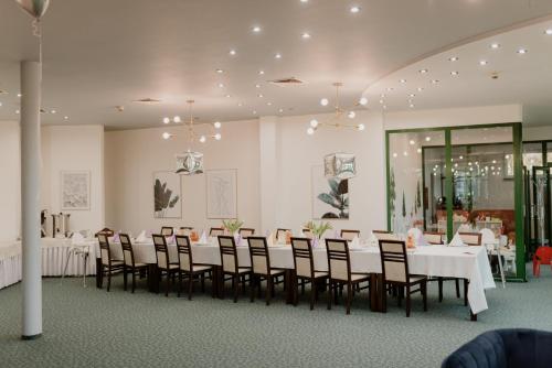 a dining room with white tables and chairs at Hotel Pan Tadeusz in Osielsko