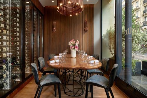 a dining room with a table and chairs and a chandelier at Maison Albar Hotels Le Pont-Neuf in Paris