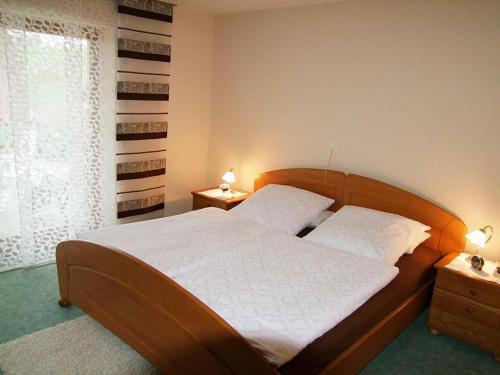 a bedroom with a large wooden bed with two lamps at Ferienwohnung Heitzinger in Bad Birnbach