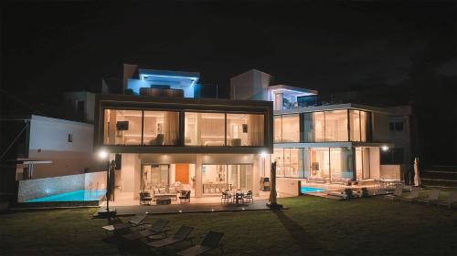 a large house at night with chairs in front of it at Mythical Villas Zeus and Venus in Protaras