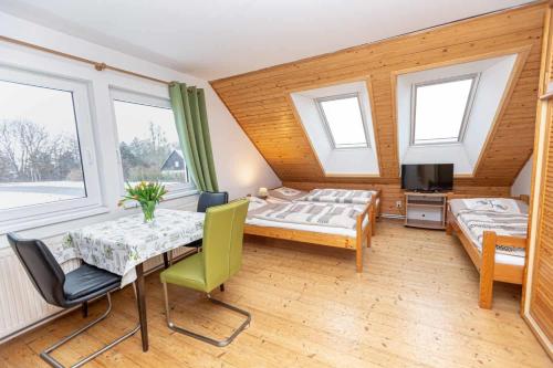 a bedroom with two beds and a table and chairs at PENZION NA VÝSLUNÍ in Nové Město nad Metují