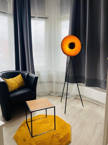 an orange lamp in a living room with a couch at City Pension Bremerhaven in Bremerhaven