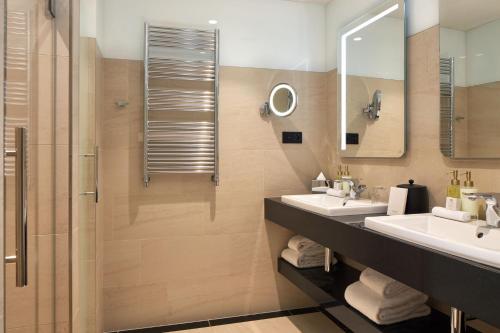 a bathroom with two sinks and a shower at Maison Albar - Le Pont-Neuf in Paris