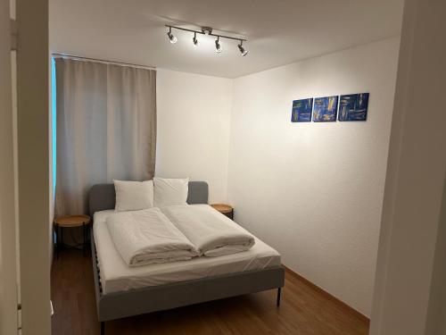 a bedroom with a bed with white sheets and pillows at Galaxy Apartments Lucerne in Luzern