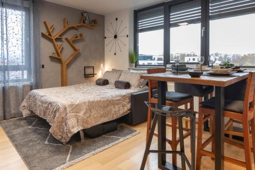 a bedroom with a bed and a desk and a table at New Gallery Best West Apartment 310 in Zagreb