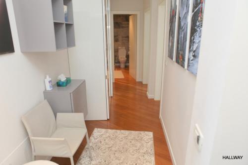 a living room with a white chair and a hallway at Luxury Marina View Apartment Izola in Izola