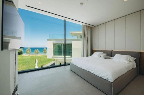 a bedroom with a large bed and a large window at Mythical Villas Zeus and Venus in Protaras