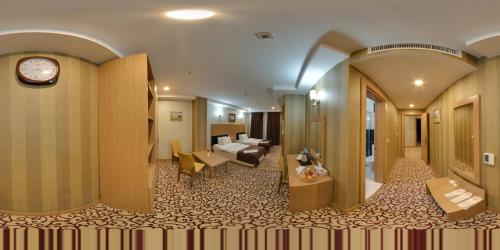 ein Hotelzimmer mit einem Wohnzimmer und einer Uhr in der Unterkunft luna hotel in Erbil