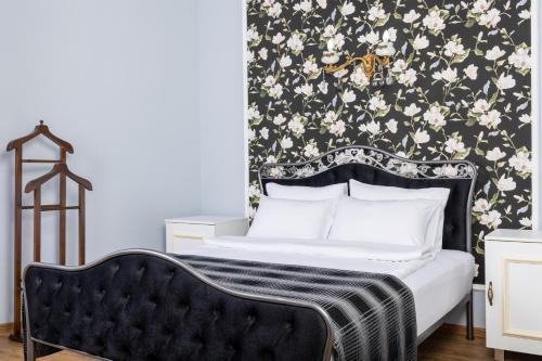 a bedroom with a bed with a black and white floral wallpaper at Rose Hotel Vake in Tbilisi City