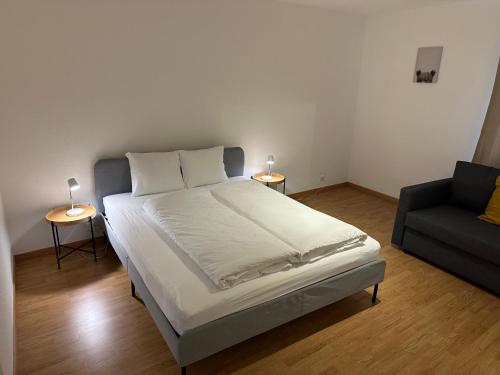 a bedroom with a large bed and a couch at Galaxy Apartments Lucerne in Luzern