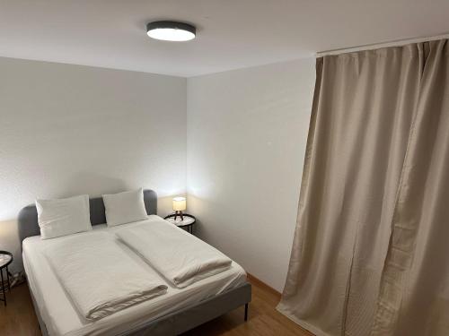 a bedroom with a bed with white sheets and a window at Galaxy Apartments Lucerne in Luzern