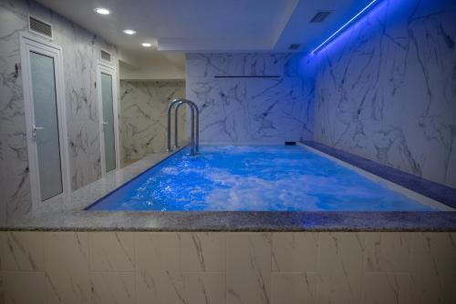 a bathroom with a large tub with blue lighting at Lime house in Kyustendil