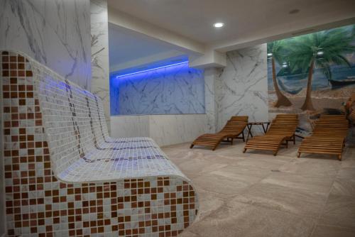 a waiting room with a bench and some chairs at Lime house in Kyustendil