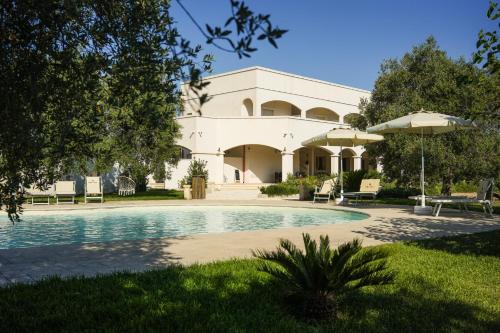 a building with a swimming pool in front of it at Villa de Lua in Leporano