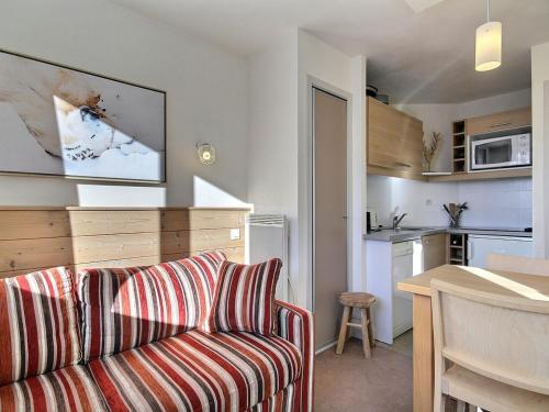 un salon avec un canapé et une cuisine dans l'établissement Studio cabine 4 pers, balcon, proche pistes et commerces - FR-1-455-183, à La Plagne Tarentaise