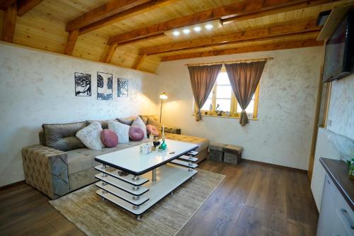a living room with a couch and a table at Sunset Lux Cottage Ravna Planina Pale - Jahorina in Pale