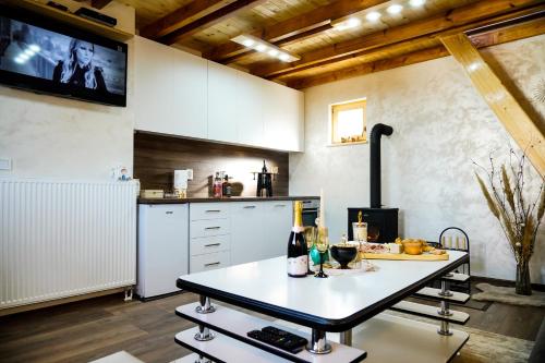 a kitchen with a table and a tv on the wall at Sunset Lux Cottage Ravna Planina Pale - Jahorina in Pale