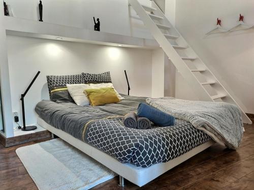 - une chambre avec un lit et une échelle dans l'établissement L'Incroyable Vue - LOFT - Parking privé gratuit, à Albi