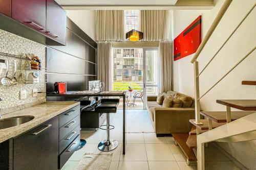 uma cozinha com um lavatório e uma mesa num quarto em Apartamento na Berrini próximo ao WTC em São Paulo