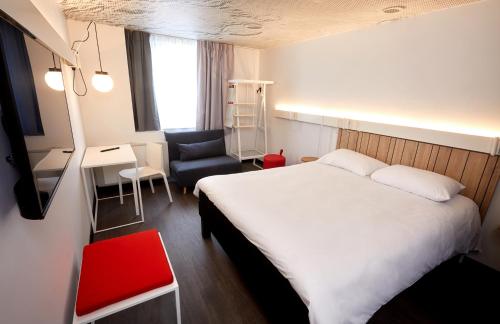 Cette chambre comprend un lit, une chaise et un bureau. dans l'établissement ibis Auxerre Centre, à Auxerre