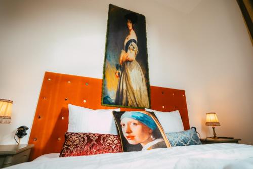 a bedroom with a bed with two portraits on it at Domaine Bohème I art de vivre in Guebwiller
