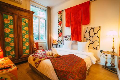 a bedroom with a bed in a room with red curtains at Domaine Bohème I art de vivre in Guebwiller