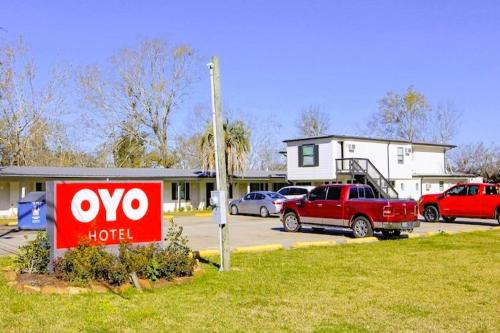 a hotel sign in a parking lot in front of a house at OYO Hotel Sulphur LA Hwy 90 West in Sulphur
