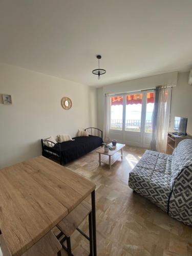 un salon avec une table et un canapé dans l'établissement Studio Helios, à Ajaccio