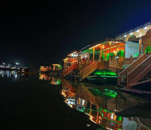 a building with lights on the water at night at Lala Rukh Group Of Houseboats in Srinagar