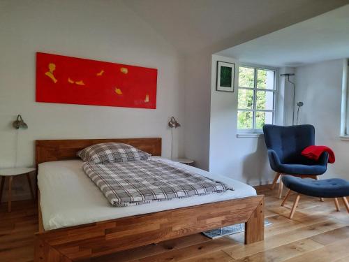 a bedroom with a bed and a blue chair at Idyllisches Schwedenhaus in ruhiger Hanglage in Oetzen