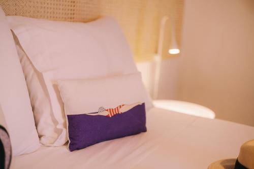 a pillow sitting on top of a bed at Mikra Bay Vineyard Guesthouses in Naxos Chora
