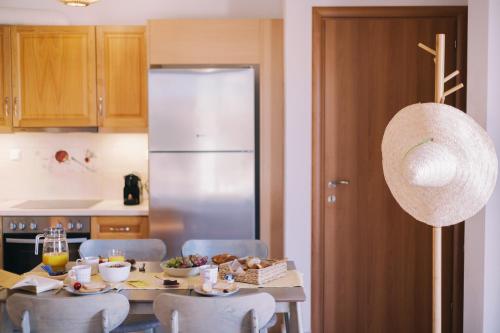 a kitchen with a table with chairs and a refrigerator at Mikra Bay Vineyard Guesthouses in Naxos Chora