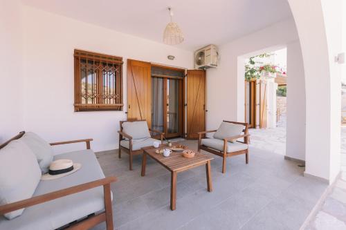 a living room with a table and chairs at Mikra Bay Vineyard Guesthouses in Naxos Chora