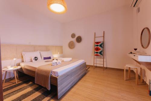 a bedroom with a bed and a table and a mirror at Mikra Bay Vineyard Guesthouses in Naxos Chora