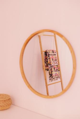 a mirror with a wooden frame on a wall at Mikra Bay Vineyard Guesthouses in Naxos Chora