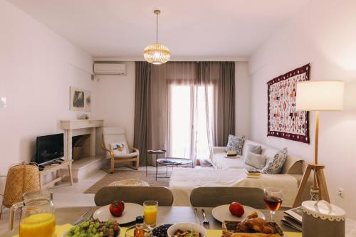 a living room with a couch and a table with food at Mikra Bay Vineyard Guesthouses in Naxos Chora
