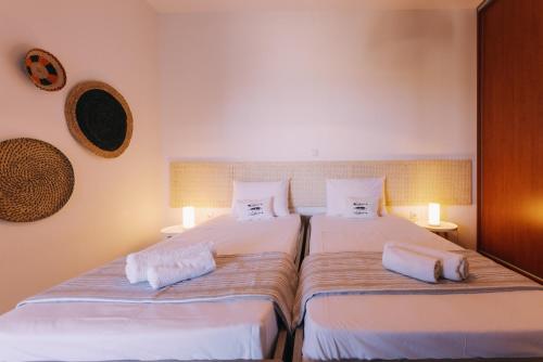 two beds sitting next to each other in a bedroom at Mikra Bay Vineyard Guesthouses in Naxos Chora