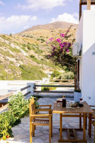 a table and two chairs on a patio with a view at Mikra Bay Vineyard Guesthouses in Naxos Chora